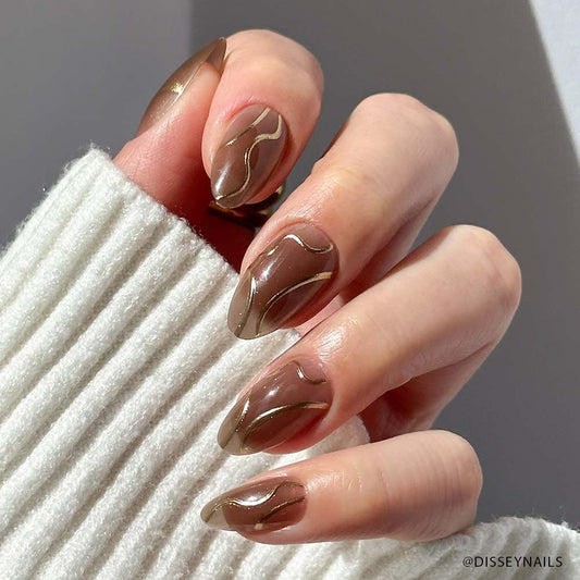 Hand with brown nail art holding a white textured fabric